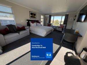 a bedroom with a bed and a couch and a table at Cambridge Te Awa Rivertrail BnB in Cambridge