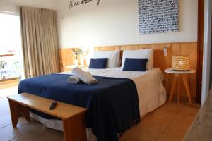 a bedroom with a large bed with a blue blanket at Pousada Village Gostoso in São Miguel do Gostoso +3 photos