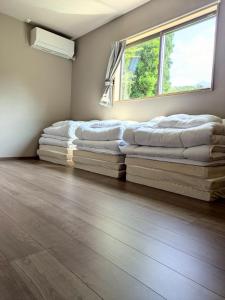 two beds sitting in a room with a window at 南阿蘇サウナ5gaku G1 in Minami Aso