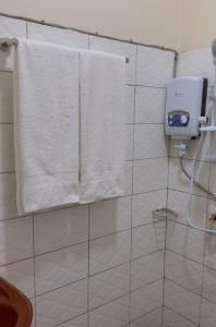 a bathroom with white towels hanging on a wall at Moods Holiday Homes in Kampala