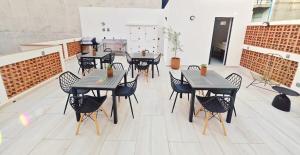 un patio con mesas negras y sillas en un edificio en Luz Maria 8 MaiaHome Prime Spot in Polanco with Terrace, en Ciudad de México