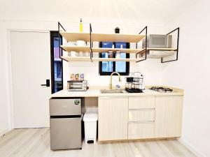 Una pequeña cocina con fregadero y microondas. en Luz Maria 8 MaiaHome Prime Spot in Polanco with Terrace, en Ciudad de México 5 fotos más
