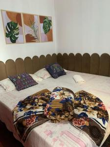 a bed with blankets and pillows on top of it at Novo Milenio Casa Beach in Santos