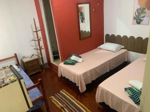 a room with two beds and a mirror at Novo Milenio Casa Beach in Santos +15 photos