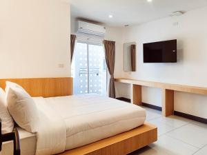 una camera d'albergo con un letto e una TV a schermo piatto di Laksika Place Khao Rang a Phuket