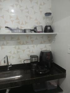a kitchen counter with a sink and a coffee maker at Apartamento térreo in Vitória