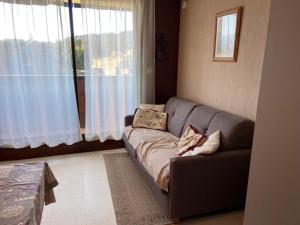 un soggiorno con divano di fronte a una finestra di Studio central Praz de Lys - 4 pers, balcon, proche pistes - FR-1-815-33 a Taninges