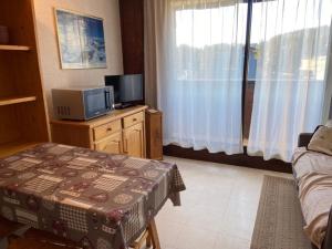un soggiorno con TV, tavolo e tvictericterericter di Studio central Praz de Lys - 4 pers, balcon, proche pistes - FR-1-815-33 a Taninges