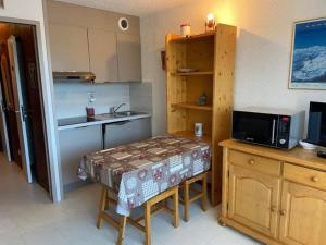 una piccola cucina con un tavolo e un microonde di Studio central Praz de Lys - 4 pers, balcon, proche pistes - FR-1-815-33 a Taninges