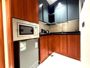 a kitchen with a refrigerator and a microwave at wafia hotel in Al Ḩāyiţ