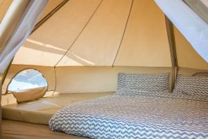 Una cama en una tienda con una almohada. en Cannaverde - Amalfi Coast Camp, en Maiori