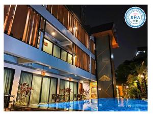 a building with a swimming pool in front of it at Lanna Tree Boutique Hotel in Chiang Mai +5 photos