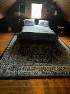 1 cama en un dormitorio con alfombra en el suelo en Starboat Log Home, en Jersey Shore