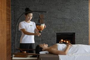 a woman laying on a bed while a man is holding a mixer at The Lalu Sun Moon Lake in Yuchi +20 photos