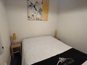 ein Schlafzimmer mit einem Bett und zwei Tischen mit Lampen in der Unterkunft Appartement Sud avec Terrasse et Garage à Super Besse - FR-1-814-96 in Besse-et-Saint-Anastaise