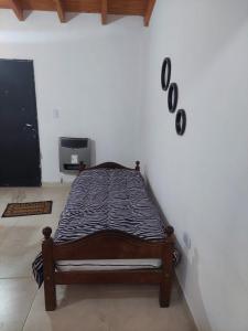 a bed sitting against a wall in a room at Nat depto in Senillosa