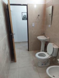 a bathroom with a toilet and a sink at Nat depto in Senillosa