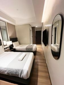 a hotel room with two beds and a mirror at Vibe Hotel Alabang in Manila +28 photos