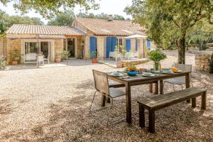 a table and a bench in front of a house at La Mathilde - Premium Pool Villa Private Tree-Top Adventure in Bonnieux