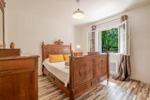 a bedroom with a wooden bed and a window at La Mathilde - Premium Pool Villa Private Tree-Top Adventure in Bonnieux +20 photos