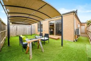 a patio with a table and chairs under a roof at Modern 2BR Comfort in the Heart of Officer in Officer