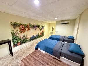 a room with two beds and a painting on the wall at TipThong Hut - Tropic Garden Resort in Rayong