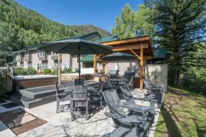 a patio with chairs and tables and umbrellas at Mountainside Inn 309 by Alpine Lodging Telluride in Telluride