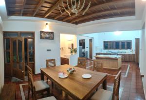 a kitchen and dining room with a wooden table and chairs at Mountain View Villa Vacation Rental in Idukki