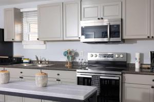 a kitchen with white cabinets and stainless steel appliances at 5 Min to Elon - In Unit Washer and Dryer - Fast Wi-Fi in Burlington