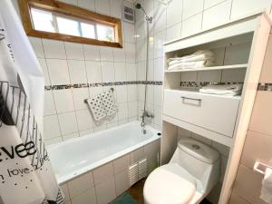 un bagno con wc e vasca da bagno di ApartHotel Cuatro Estaciones Frutillar Bajo a Frutillar Altre 54 foto
