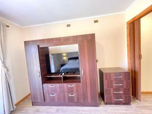 un grande mobile in legno con specchio in una camera da letto di ApartHotel Cuatro Estaciones Frutillar Bajo a Frutillar