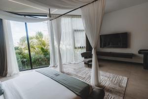 a bedroom with a bed with a large window at AMO Residences in Canggu