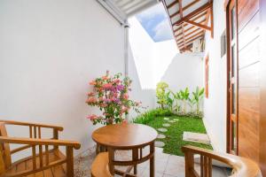 a small patio with a wooden table and chairs at Bale Ayem Prambanan Homestay Jogja in Bugisan
