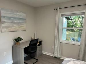 a desk with a chair in a room with a window at 10 Min to Downtown - Desk - Fenced Yard - Wi-Fi in Raleigh +30 photos