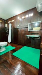 Un baño con alfombras verdes en el suelo y un ventilador. en Sukhothai City Resort, en Sukhothai 162 fotos más