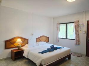 a bedroom with a bed with a blue robe on it at D.R. Lanta Bay Resort in Ko Lanta