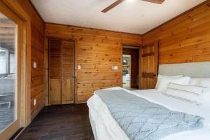 a bedroom with wooden walls and a large bed at Aska's Cozy Corner Cabin in Cherry Log