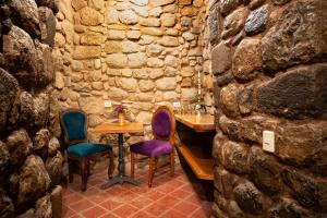 a stone walled room with a table and chairs at Casa Amará in Cusco