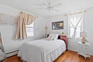 a white bedroom with a bed and a ceiling fan at NEW " Fall Season " cozy 2 bed flat with open concept in Scranton +27 photos