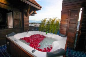 a bath tub with red flowers in it on a balcony at Singha Montra Lanna Boutique Style Hotel in Chiang Mai