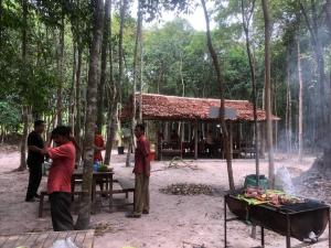 a group of people standing outside of a building in the woods at Chansor Homestay 3 By Siem Reap Homesteading in Phumĭ Trach Pôk (2)