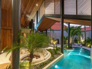 an indoor courtyard with a swimming pool in a house at Villa Levante Bali by House of Winds - Tropical Oasis near Canggu in Kerobokan