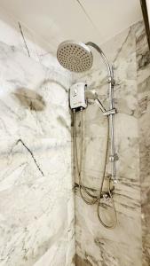 een douche in een badkamer met een witte marmeren muur bij Cozy condo maikhao Phuket in Ban Mai Salae +15 foto's