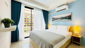 een slaapkamer met een bed en een raam bij Cozy condo maikhao Phuket in Ban Mai Salae