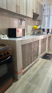 a kitchen with wooden cabinets and a counter top at Stylish 1 Bedroom Apartment in Kitengela 