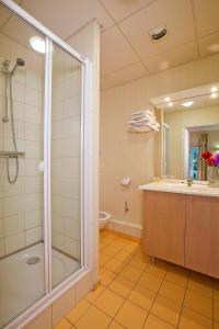 a bathroom with a shower and a tub and a sink at Hotels & Résidences - Les Thermes in Luxeuil-les-Bains