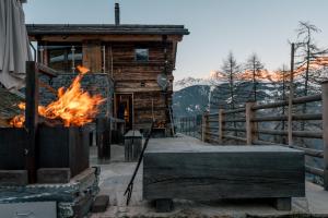 eine Feuerstelle vor einem Blockhaus in der Unterkunft Mybruson in Bruson