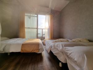 two beds in a room with a window at 南海難波駅徒歩1分 in Osaka +8 photos
