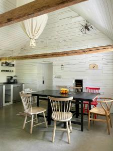 a dining room with a black table and chairs at Renovated Scanian Farmhouse With Two Studios in Skåne-Tranås