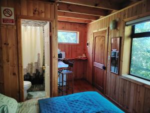 a bedroom with a bed and a bathroom with a sink at Cabañas y Hostal Karibe in Pichilemu